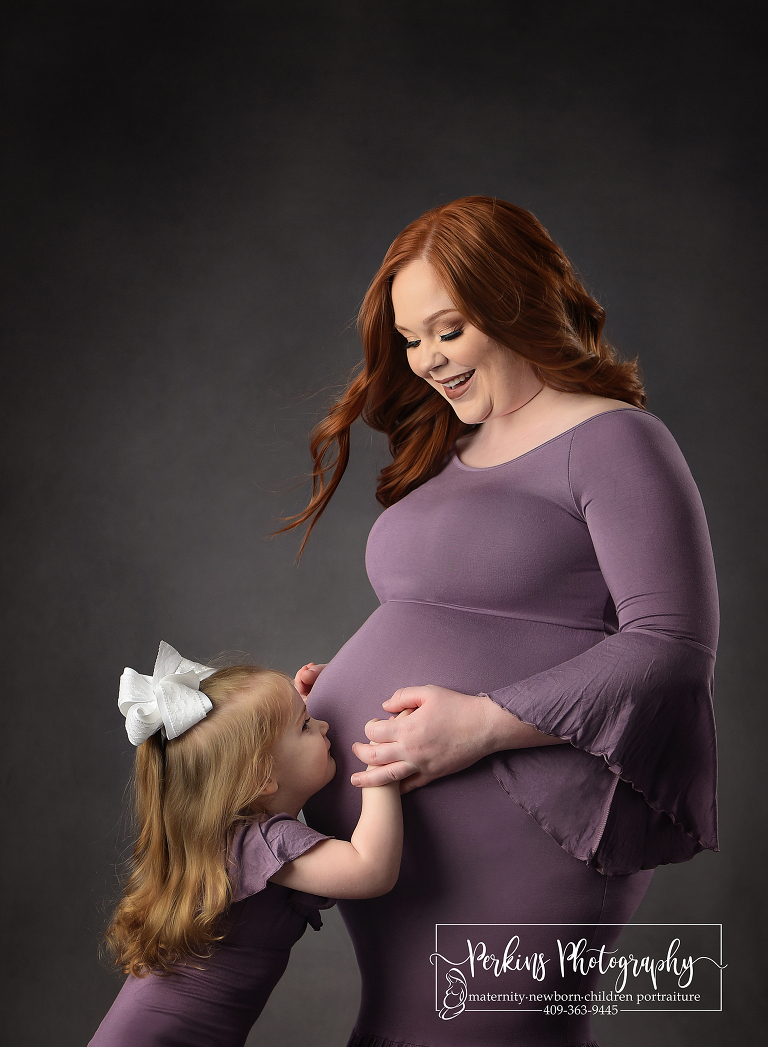 Toddler and pregnant mom posing in purple dress